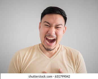 Headshot of crazy laughing face of Asian man with beard and mustache.