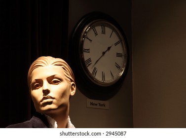 Headshot Of A Generic Mannequin With A Wall Clock.