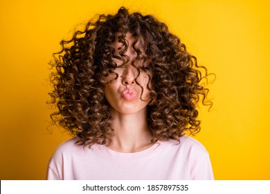 Headshot of girl with curly hairstyle wearing t-shirt send air kiss pouted lips isolated on vivid yellow color background - Shutterstock ID 1857897535