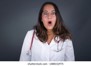 Headshot Of Goofy Surprised Bug-eyed Young Doctor Woman Staring At Camera With Shocked Look, Expressing Astonishment And Shock, Screaming Omg Or Wow