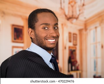 Headshot handsome man wearing business suit turning head and smiling to camera, lobby background - Shutterstock ID 470229476