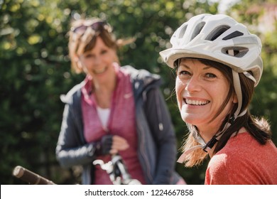 Headshot Of A Mature Female Wearing A Cycling Helmet And Looking At The Camera And Smiling.