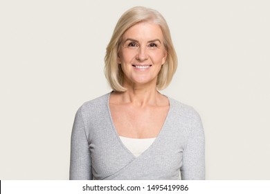 Headshot Picture Of Happy Caucasian Senior Woman Stand Isolated On Grey Studio Background Look At Camera, Portrait Of Smiling Aged Female With Gray Hair Stand Posing, Elderly Help Assistance Concept