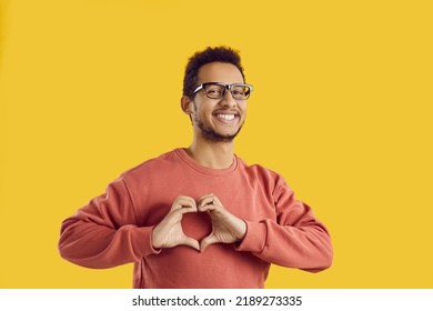 Headshot picture of smiling young black man isolated on yellow studio background show heart hand gesture. Portrait of happy African American guy demonstrate love sign share affection and care. - Powered by Shutterstock