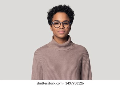 Headshot portrait of beautiful african American millennial woman in glasses and sweater stand isolated on grey studio background, black biracial female wearing spectacles look at camera posing - Shutterstock ID 1437938126