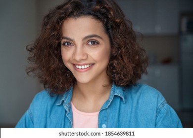Headshot portrait of beautiful smiling young Hispanic woman looking at camera at home. Happy student blogger making online dating, doing job interview during video chat conference call, record vlog.