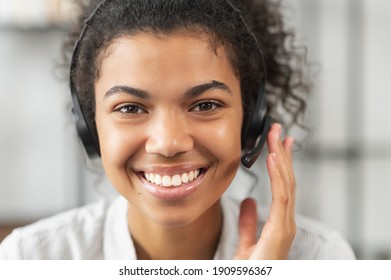 Headshot portrait close-up smiling African American woman support service operator in headset wireless headphones with microphone, smiling, working and looking at the camera, satisfied worker concept - Powered by Shutterstock