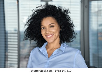 Headshot portrait of confident smiling successful African American businesswoman executive top manager looking at camera posing in modern contemporary corporate office. Business corporate concept.