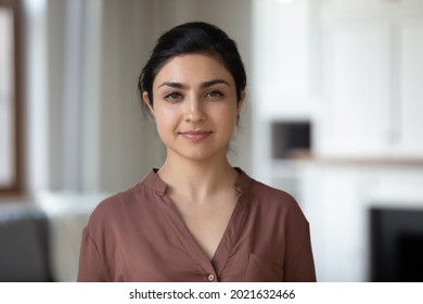 Headshot Portrait Of Confident Young Indian Woman Renter Or Tenant Pose In Modern Own New Apartment Or House. Profile Picture Of Millennial Mixed Race Female Look At Camera. Diversity Concept.