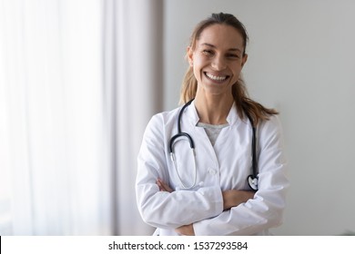 Headshot Portrait Of Happy Caucasian Female Doctor Wearing Whites With Stethoscope On Shoulder Posing In Hospital, Smiling Woman Nurse In Medical Uniform Look At Camera In Clinic, Healthcare Concept