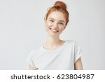 Headshot Portrait of happy ginger girl with freckles smiling looking at camera. White background.