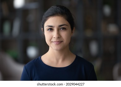 Headshot portrait of happy millennial Indian woman look at camera posing in own house or apartment. Profile picture of smiling young mixed race female renter tenant. Rent, real estate concept.