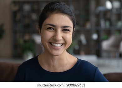 Headshot portrait of happy millennial woman of indian ethnicity make video call from home talk on gadget webcam on training webinar conference. Profile picture of teen ethnic female at social network