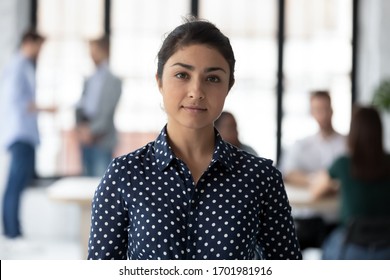 Headshot portrait of happy successful young Indian female employee posing in modern office, smiling confident millennial biracial woman worker show motivation at workplace, leadership concept - Powered by Shutterstock