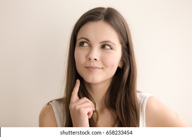 Headshot portrait of pensive young woman. Beautiful teen girl with thoughtful facial expression thinking about interesting idea. Cute lady ponders decision, dreaming about future. Close up. Front view - Shutterstock ID 658233454
