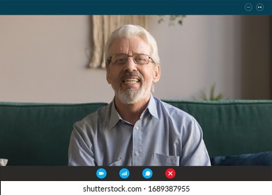 Headshot Portrait Screen Application View Of Elderly Grandfather Sit On Couch At Home Talk On Video Call With Relatives, Happy Senior Man Communicate Online Using Webcam On Modern Computer Gadget