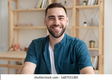 Headshot portrait of smiling Caucasian young male employee look at camera posing at workplace, happy European businessman show confidence and motivation for future career success, leadership concept