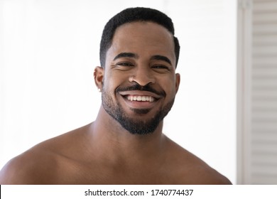 Headshot Portrait Of Smiling Handsome African American Young Man Look Fresh After Morning Procedures In Home Bathroom, Happy Millennial Biracial Male Look At Camera In Bath, Hygiene, Skincare Concept