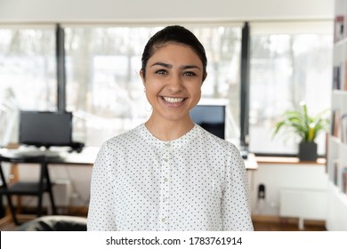 Headshot Portrait Of Smiling Indian Female Employee Look At Camera Pose In Office, Profile Picture Of Happy Millennial Biracial Woman Worker Show Confidence Success At Workplace, Leadership Concept