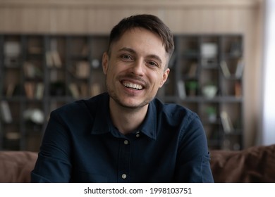 Headshot portrait of smiling millennial Caucasian man look at screen camera have webcam virtual event. Profile picture of happy young male talk speak on video call at home. Communication concept.