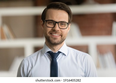 Headshot Portrait Of Smiling Young Caucasian Businessman In Suit And Glasses Pose In Office. Profile Picture Of Happy Successful Male Director Or CEO Show Leadership And Optimism. Success Concept.