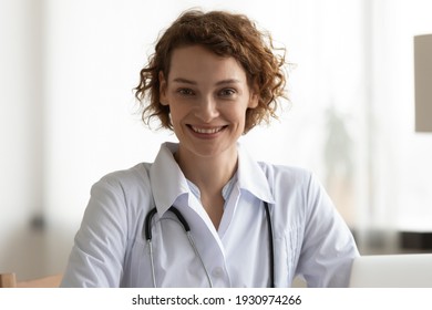 Headshot portrait of smiling young Caucasian female doctor in white uniform work in hospital. Profile picture of happy woman nurse or GP pose at workplace in private clinic. Healthcare concept.