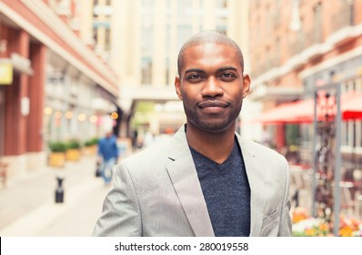 Headshot portrait of young man smiling isolated on outside outdoors background.