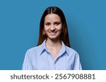 Headshot portrait of young smiling with teeth teenage girl on blue background