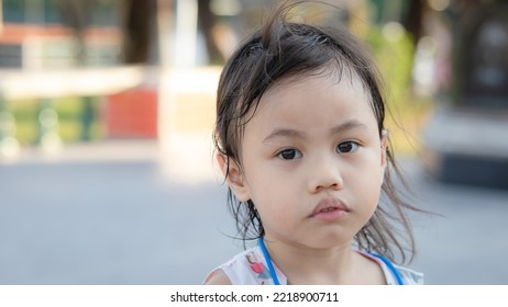 Headshot Of Sad 4 Years Old Cute Baby Asian Girl, Little Toddler Child With Adorable Short Hair Making Frustrated Face, Looking Camera With Copy Space Background.