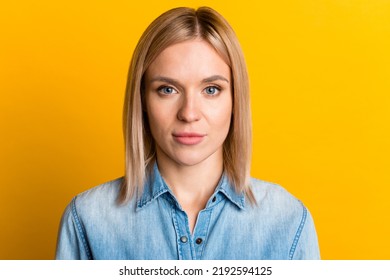 Headshot Of Serious Young Female Wearing Hirt Looking At Camera Standing Isolated At Studio Wall.