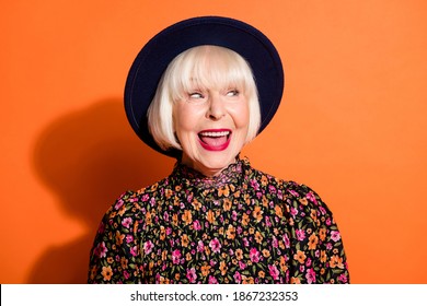 Headshot Of Sly Curious Old Woman Looking Blank Space Smiling Red Lipstick Wearing Blouse Headwear Isolated Vivid Orange Color Background