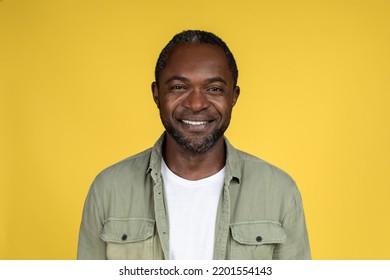 Headshot Of Smiling Confident Adult African American Male In Casual Looking At Camera, Isolated On Yellow Background, Studio, Close Up, Free Space. People Emotions And Facial Expression, Ad And Offer