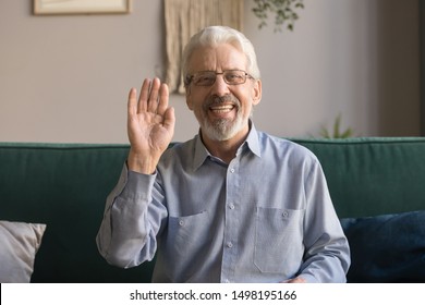 Headshot Of Smiling Mature Man Sit On Couch Look At Camera Waving Having Video Call On Computer, Happy Senior Grandfather, Elderly Male Talk Using New Technologies, Fast Internet Connection On Gadget