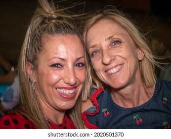 A Headshot Of Two Happy Spanish Women Having Fun At The Party