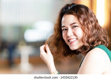 Headshot Of Young Happy Attractive Asian With Trendy Curly Brunette Hair Stylish Female Designer Or Influencer Smiling And Looking At Camera With Confident And Positive. Portrait Of Asian Cute Girl.