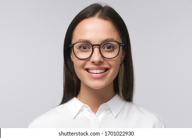 Headshot Of Young Smiling Business Female, Wearing Glasses And White Collar Shirt, Feeling Confident, Staying Positive, Isolated On Gray Background