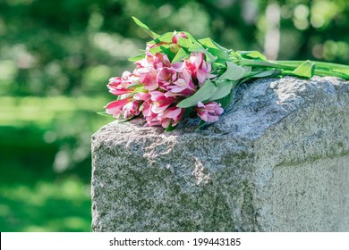 Headstone In Cemetery With Flowers For Concept Of Death And Loss