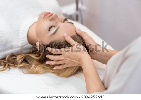 Healer performing by lightly touched access bars therapy on young woman head, stimulating positive change thoughts and emotions. Alternative medicine concept. High quality photo