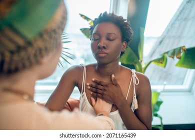 A healer working with a dark-skinned woman