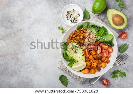 healhty vegan lunch bowl. Avocado, quinoa, sweet potato, tomato, spinach and chickpeas vegetables salad. Top view
