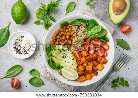 healhty vegan lunch bowl with ingredients. Avocado, quinoa, sweet potato, tomato, spinach and chickpeas vegetables salad. Top view
