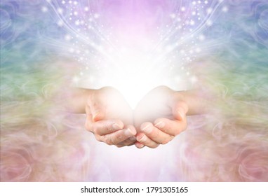 Healing is a magical experience  - female hands with with white light and a flow of sparkles against a pale rainbow coloured background with room for messages
                               