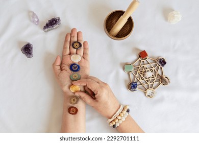 Healing reiki chakra crystals on woman's hands. Gemstones therapy for wellbeing, meditation, destress, relaxation, metaphysical, spiritual practices. Energetical power concept