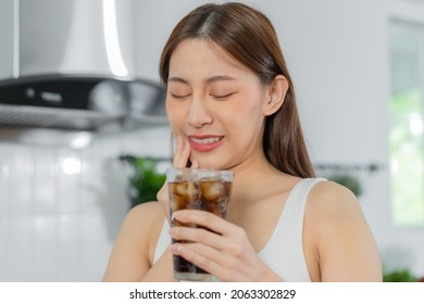 Health asian young woman touching cheek, expression, suffering from toothache, decay or sensitivity cavity molar tooth, teeth or inflammation drink cold, sparkling water at home.Sensitive teeth people