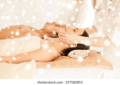 health and beauty concept - couple in spa salon getting face treatment