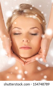 health and beauty concept - woman in spa salon getting face treatment
