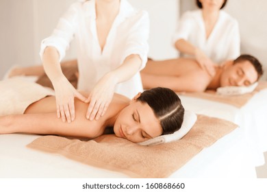 Health And Beauty, Resort And Relaxation Concept - Couple In Spa Salon Getting Massage
