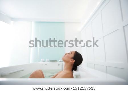 Health and beauty treatment concept. Side on portrait of calm satisfied asian woman having relaxing and healthy spa bath