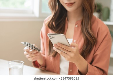 Health care asian young woman using smart mobile for reading, searching prescription medicine, pills label text about medical information online, instructions side effects, pharmacy medicament concept - Powered by Shutterstock