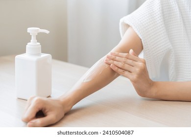 Health care, beauty smile pretty asian young woman in bathrobe, towel after shower bath at home, hand applying, putting moisturizer on her arm. Skin body cream moisturizing lotion, routine in morning. - Powered by Shutterstock